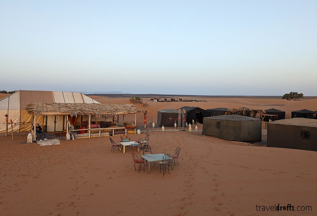Experimente uma excursão ao deserto do Saara neste acampamento no deserto, com várias tendas, mesas e cadeiras ao ar livre na areia dourada, tudo sob uma grande tenda com dossel. Desfrute da paisagem aberta de cortar a respiração sob um céu deslumbrante ao nascer ou ao pôr do sol.